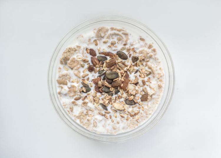 Oatmeal mixed with yogurt and seeds in a jar.