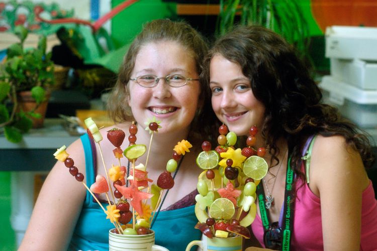 Girls making fruit center pieces