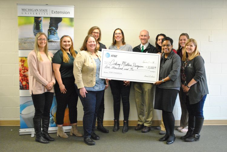 Yvette Collins, director of external affairs for AT&T, presents MSU Extension with a $10,000 