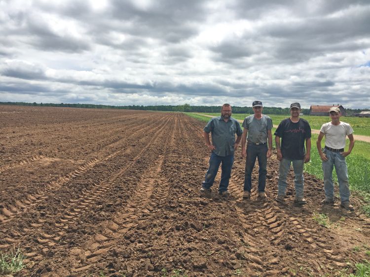 Four men standing out in an empty field