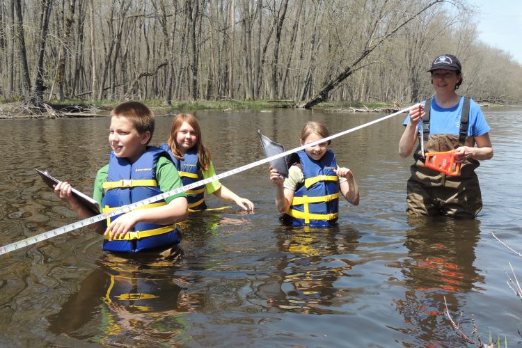 Youth and teacher wading in water