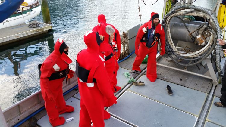 Alaska commercial fishermen on a purse seine vessel donning immersion suits as part of a Drill Conductor Training course. Ron Kinnunen | Michigan Sea Grant