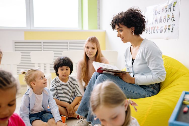 A woman reading a book to children.