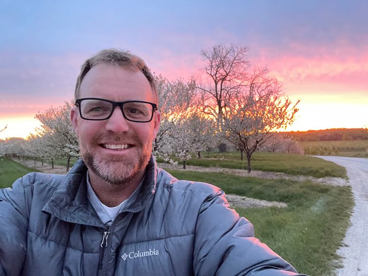 Brian Matchett standing in front of trees