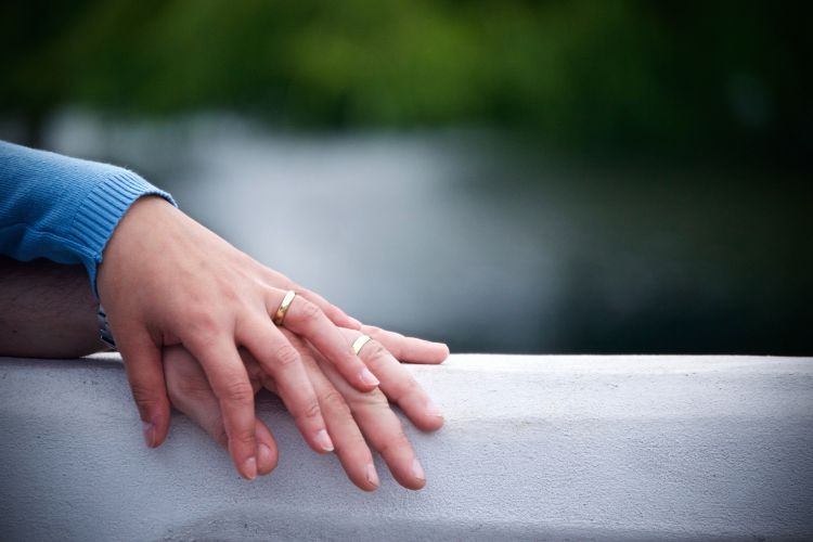 A couples hands resting on a gray surface