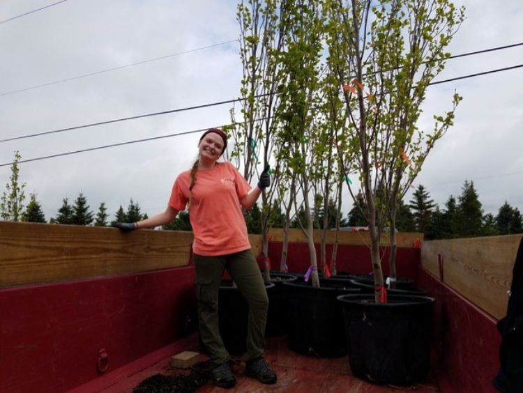 Master's student, Riley Rouse, standing in front of her research trees.