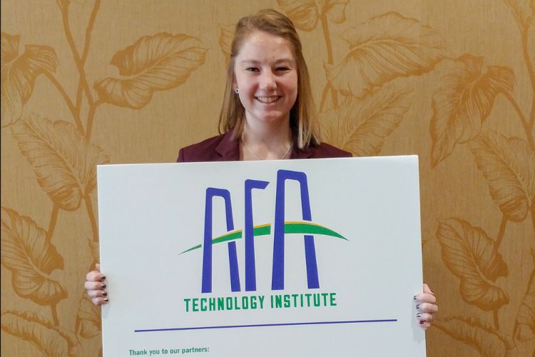 Sarah Lokey holding a sign that reads AFA Technology Institute