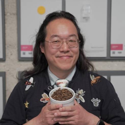 Headshot of Joseph Yoon holding a container of bugs