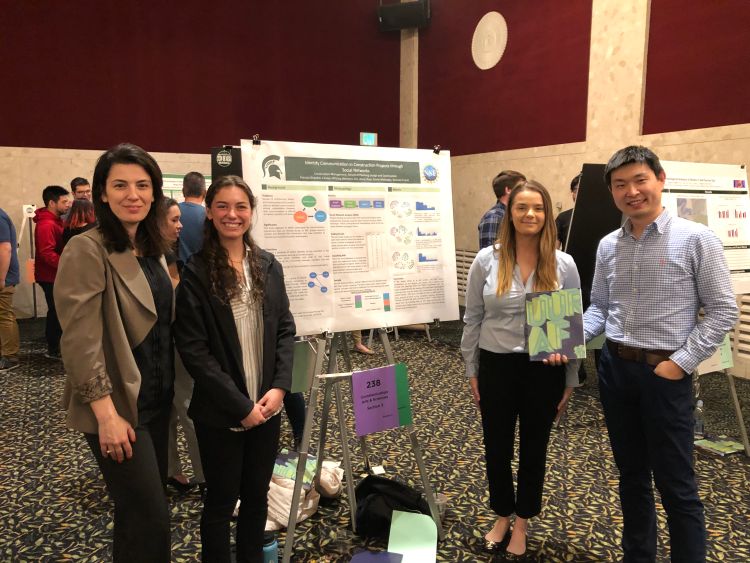 Construction Management faculty members Sinem Mollaoglu and Dong Zhao with students Patty Giradot and Carolyn Whiting standing with their award-winning poster at the 21st UURAF.