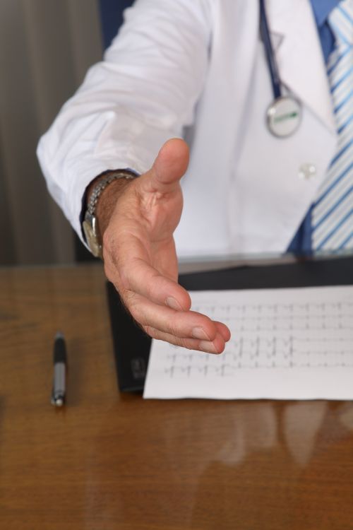 A doctor reaching his hand out to shake someone's.