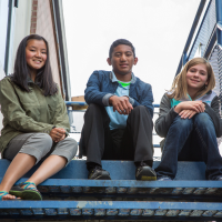 Three kids sitting on stairs