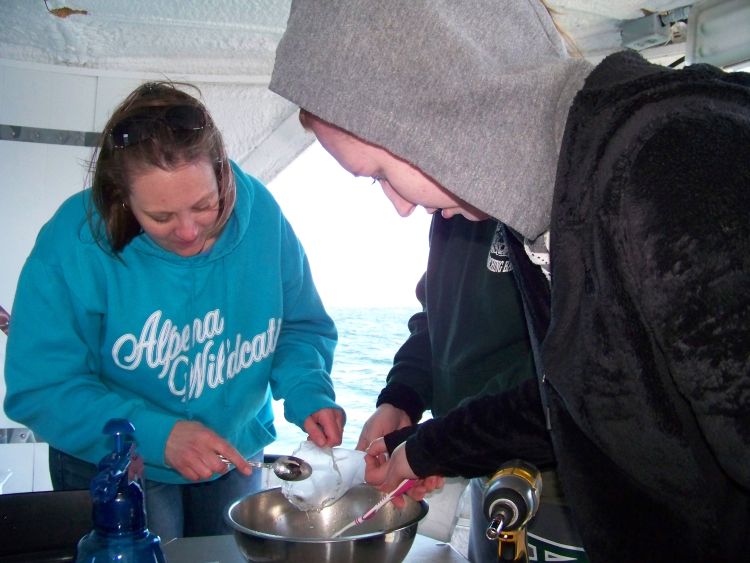 Alpena teacher Melissa Smith sorts trawl samples with students aboard the Nancy K research vessel. Helen-Ann Cordes | Michigan State University Extension.