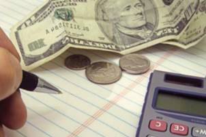 Calculator, a pen, and a $10 bill in a photo.