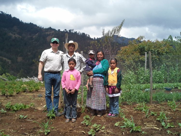 MSU researcher poses with a Guatemalan family in one of their bean fields