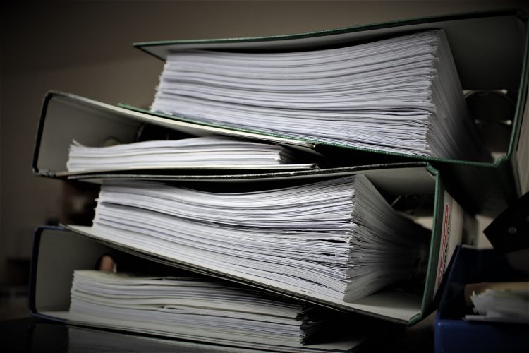 Stack of binders with papers inside each.