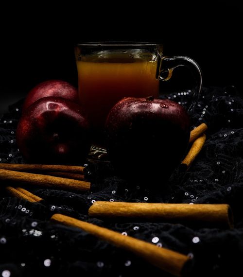 Apple cider in a mug with cinnamon sticks.