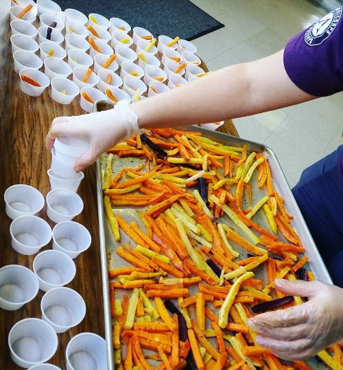 Students at Frankfort Elementary show their Panther Pride by taste testing Panther Fries. Trying the rainbow carrots, sharing which color was their favorite and voting.  Photo Credit: Stephanie Cumper