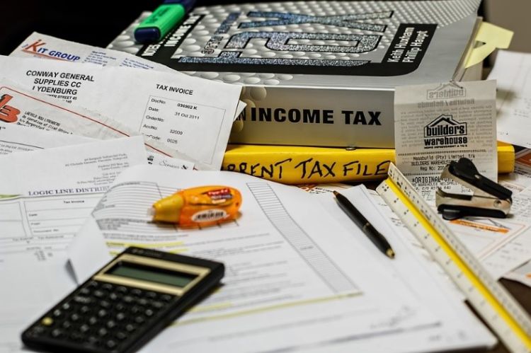 Calculator in front of tax books piled up.