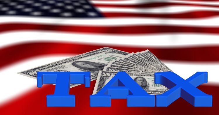 American dollars and the word tax on the American flag.