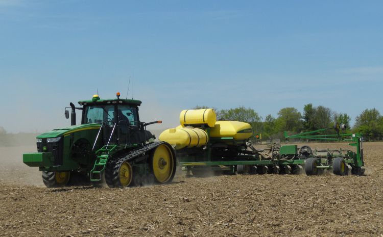 A combine planting soybeans in a field.