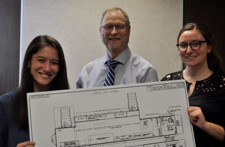 In April 2019, Gary McDowell, director of Michigan Department of Agriculture and Rural Development, visited Michigan State University for an update on the mobile food processing labs development and the on-campus fruit and vegetable lab renovations. McDowell (center) reviewed the mobile lab design concepts plans with students Lauren Kitada (left) and Katie Church at the meeting.