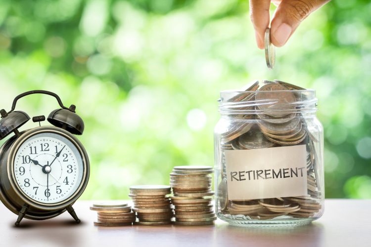 Jar labeled retirement filled with coins and an alarm clock