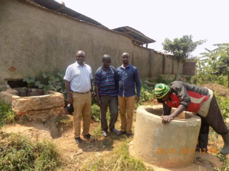 Jean de Dieu Rukundo, standing on the right, is studying dairy cow production in Rwanda.