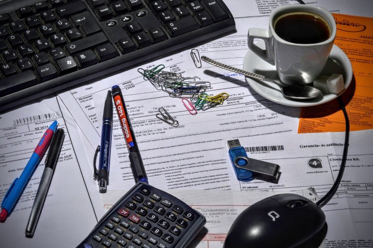 View of desk showing keyboard, mouse and other office supplies.