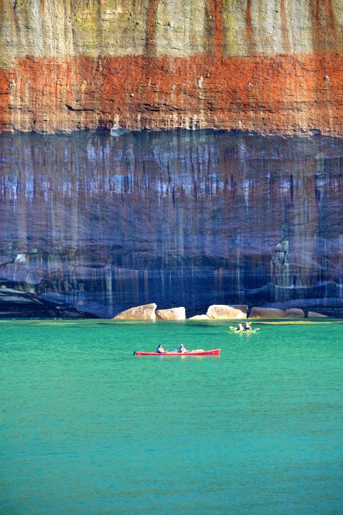 Kayakers paddle in Lake Superior near a sandstone cliff of Pictured Rocks National Lakeshore in Michigan. Photo: Todd Marsee, Michigan Sea Grant