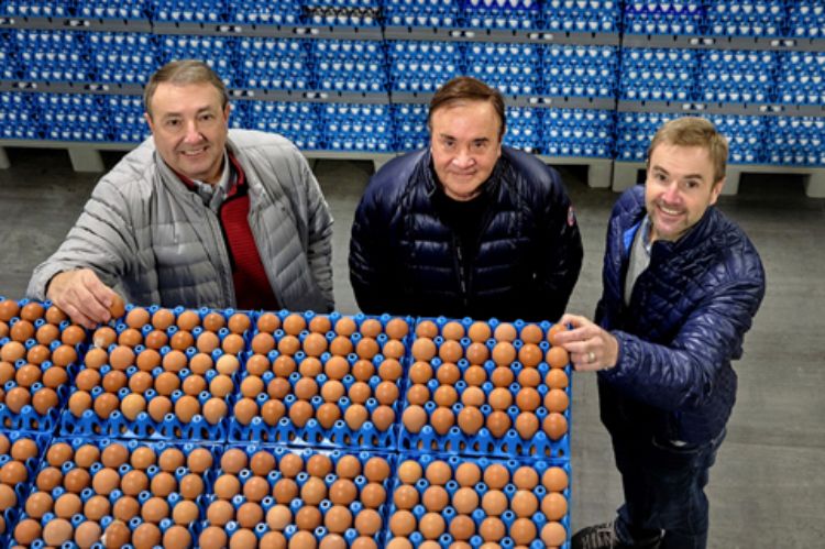 Greg Herbruck, Stephen Herbruck and Harry “Herb” Herbruck, of Herbruck’s Poultry Ranch, standing in front of many stacks of eggs in egg cartons.