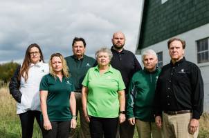 Members of the MSU Extension farm stress team pose in front of a farm.