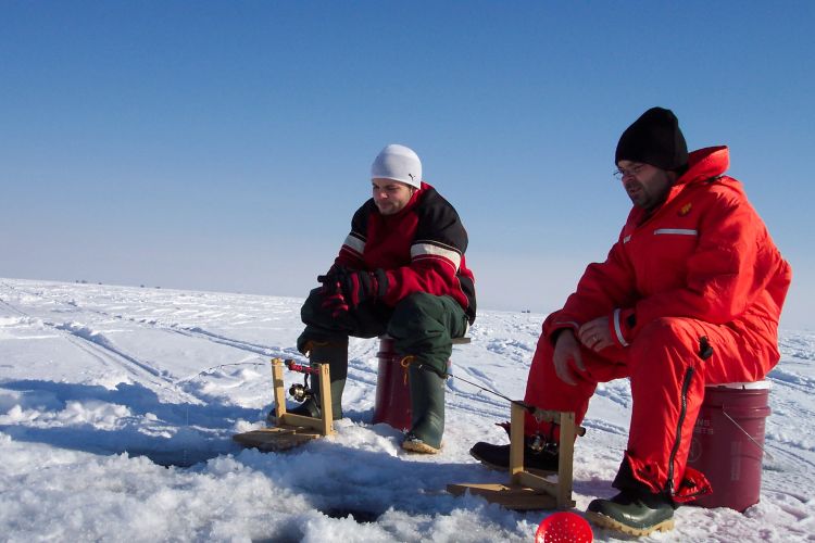 Two men ice fishing.