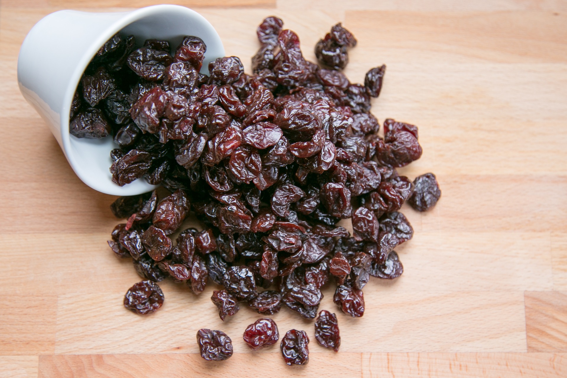Dried cherries scatter across a cutting board