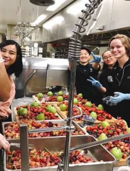 Students preparing fruit for Beauty and Beast themed meal