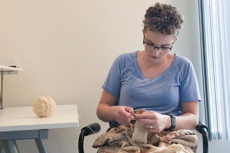 MSUAFRE PhD student Kelsey Hopkins works on a knitting project.