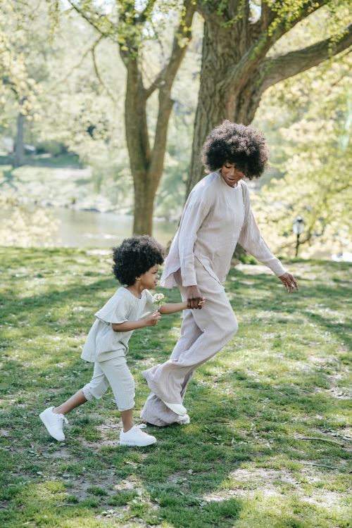 An adult and child playing outside.