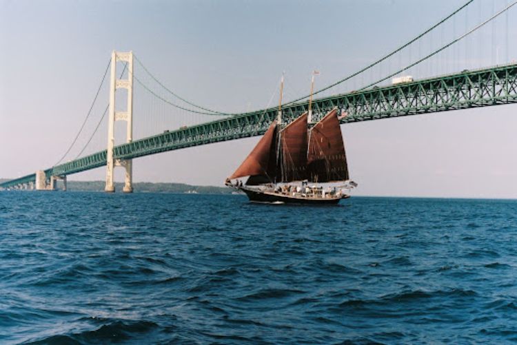 The tall ship schooner Inland Seas sails under the Mackinac Bridge. Photo: Inland Seas Education Association.