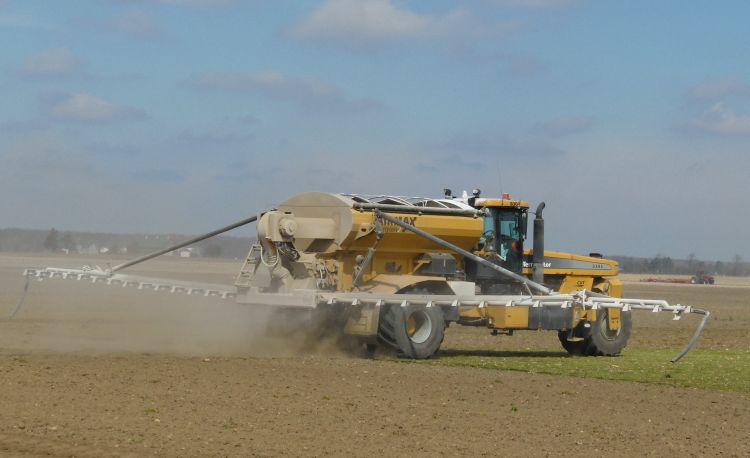 Combine spreading fertilizer on a field.