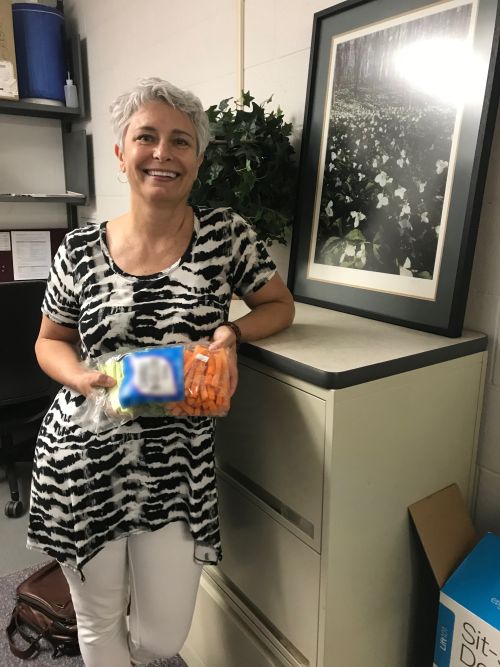 MSU Extension's Lori Trailer eat carrots in her office.