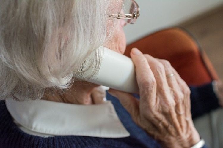 An elderly woman on a cordless phone.