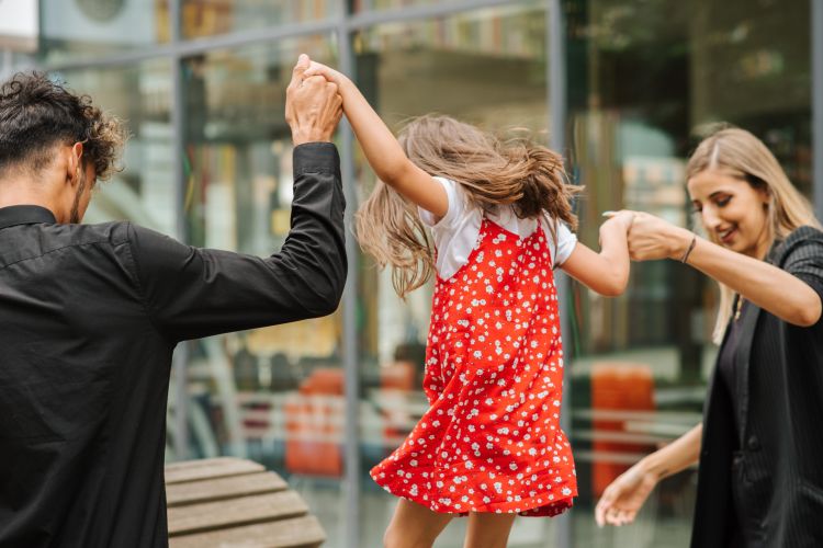 Two parents playing with a child.