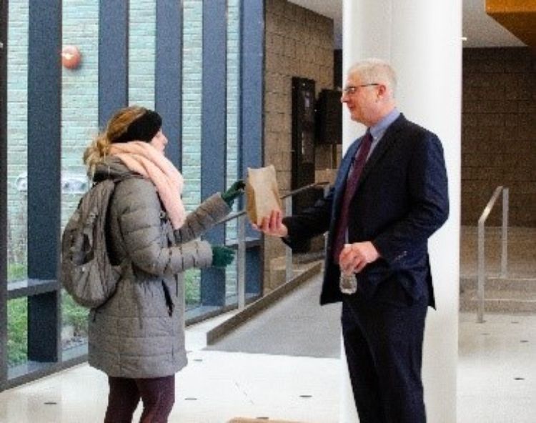 CANR Dean Ron Hendrick gives a student a Snacks for Success bag as she leaves an exam.