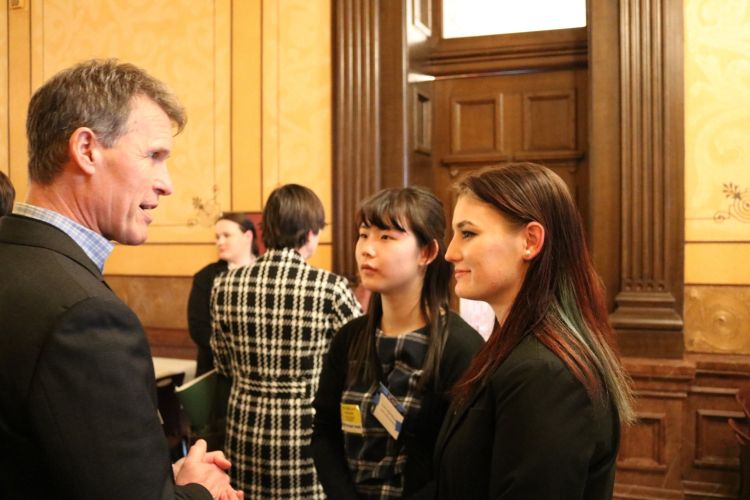 Two young adults having a conversation with someone from the Michigan Department of Agriculture and Rural Development.