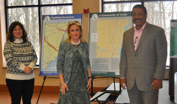 From left, Tiffany Van DeHey, owner Riverside Kayak Connection; Congresswoman Debbie Dingell; and Richard Marsh, city manager River Rouge stand in front of three sign kiosks that will be installed in 11 locations along the Downriver Linked Greenways. Photo credit: Friends of the Detroit River