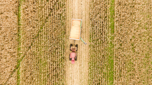 Birds eye view of a tractor cultivating fields of grass. Photo by Loren King from Pixabay.