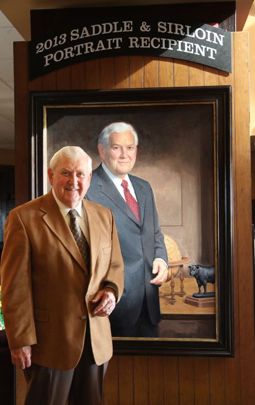 Hawkins, standing in front of his portrait that was made part of the prestigious Saddle & Sirloin Portrait Collection.