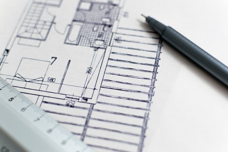 Building blue print with pen and ruler on table.