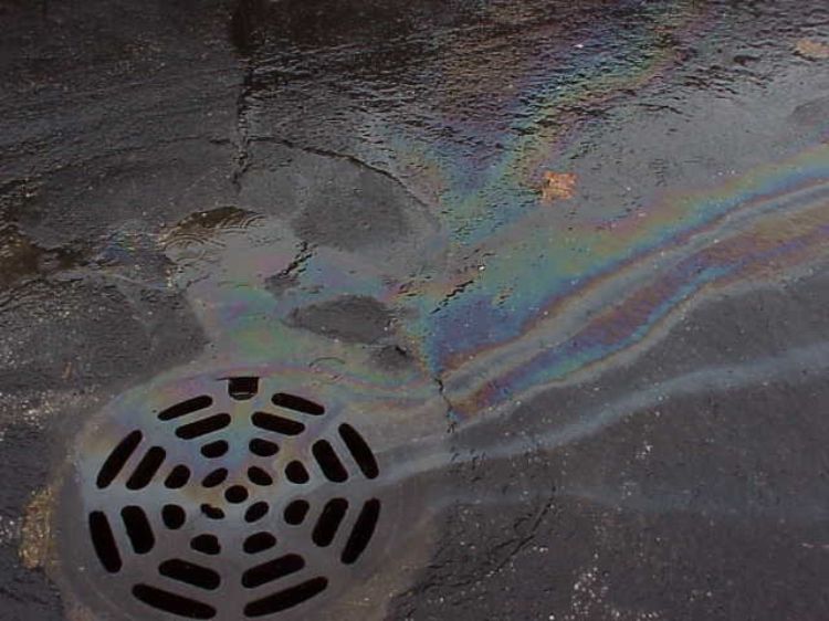 Gasoline drains into a storm drain.