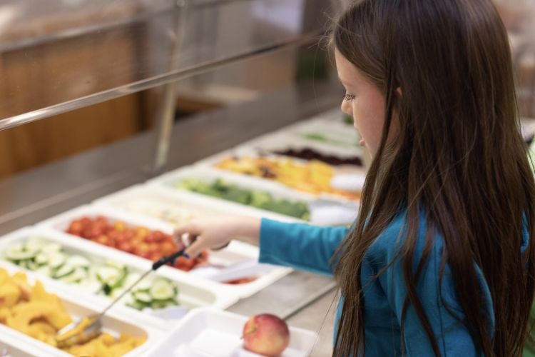 A child chooses her lunch from the school cafeteria.