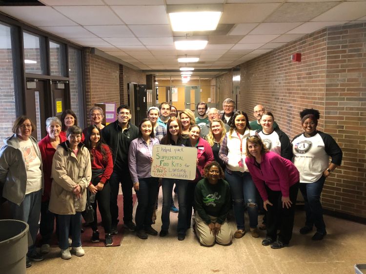 Volunteers pack supplemental nutrition kits for Lansing School District children.